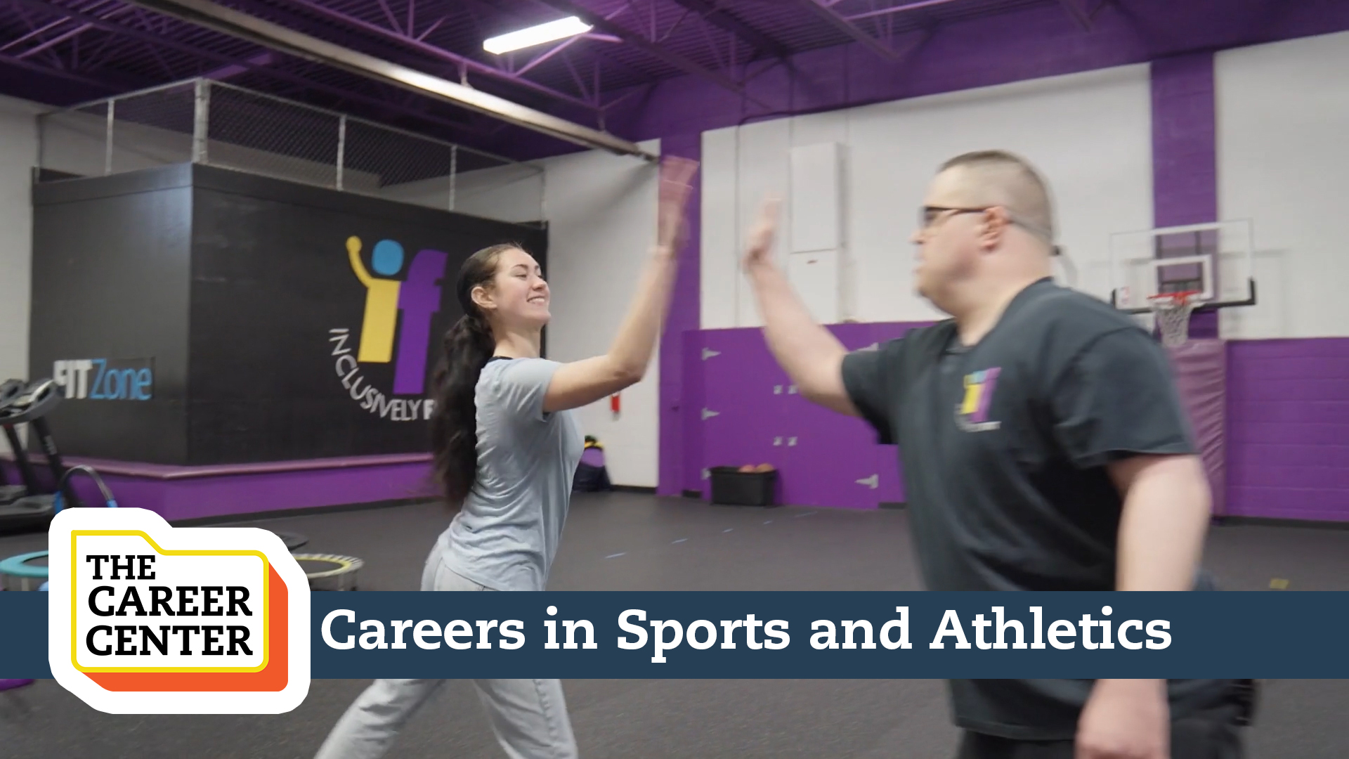 Two people high-fiving in a gym